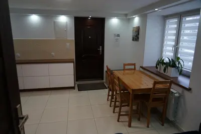 a kitchen and dining room with a wooden table and chairs at DOM NA SKARPIE in Mszana Górna