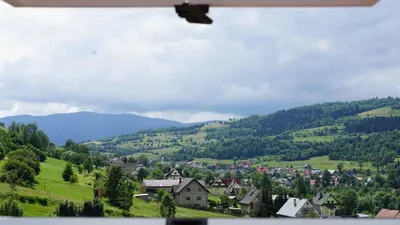 a village in a valley with mountains in the background at DOM NA SKARPIE in Mszana Górna