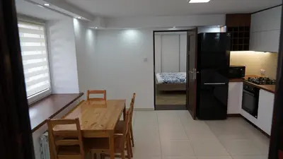 a kitchen with a wooden table and a black refrigerator at DOM NA SKARPIE in Mszana Górna