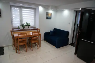a living room with a table and a blue chair at DOM NA SKARPIE in Mszana Górna