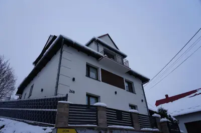 a white house with snow on the roof at DOM NA SKARPIE in Mszana Górna