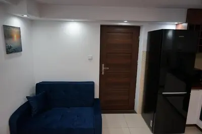 a living room with a blue couch and a door at DOM NA SKARPIE in Mszana Górna