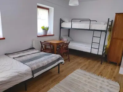 a room with two bunk beds and a table and a desk at Eko Dworek tylko 1500m do wejścia Energylandii in Zator