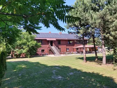 a red brick building with a yard and trees at Eko Dworek tylko 1500m do wejścia Energylandii in Zator