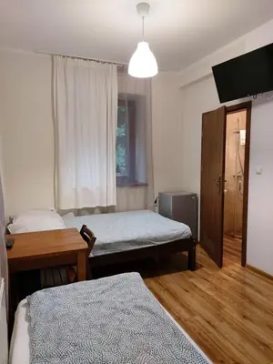 a bedroom with two beds and a desk and a window at Eko Dworek tylko 1500m do wejścia Energylandii in Zator