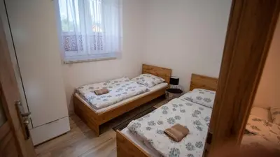 two beds in a small room with a window at U Jędrusia in Zubrzyca Górna