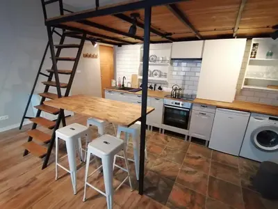 a kitchen with a wooden table and some stools at Studio Krakow old town apartment in Kraków