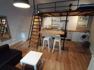 a living room with a loft bed and a kitchen at Studio Krakow old town apartment in Kraków