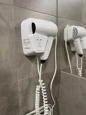 a hair dryer and a phone on a wall at Sunflower Apartment Old Town in Kraków