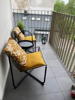 a patio with two chairs and a table on a balcony at Sunflower Apartment Old Town in Kraków