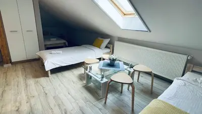 a small room with two beds and a table at Land House in Zator