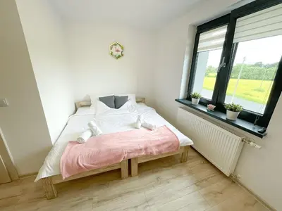 a small bedroom with a bed and a window at Land House in Zator