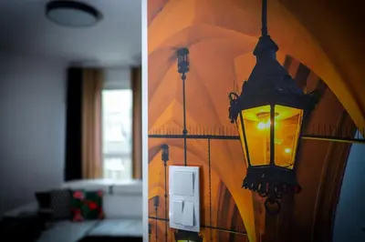 a lamp on the wall of a living room at Apartament Glamour Kraków in Kraków