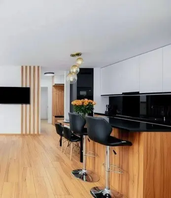 a kitchen with a table with chairs and a counter at Apartament Glamour Kraków in Kraków