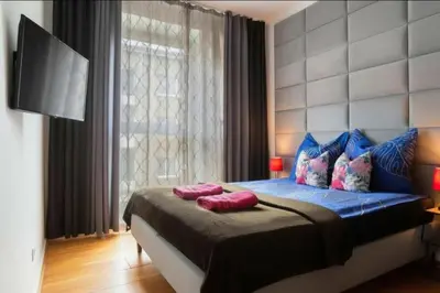 a bedroom with a bed with two pillows on it at Apartament Glamour Kraków in Kraków