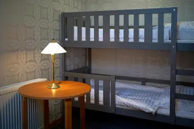 a bedroom with a bunk bed and a table with a lamp at Apartments ALKANTARA in Chrzanów