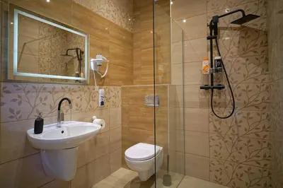 a bathroom with a toilet and a sink and a shower at Apartments ALKANTARA in Chrzanów