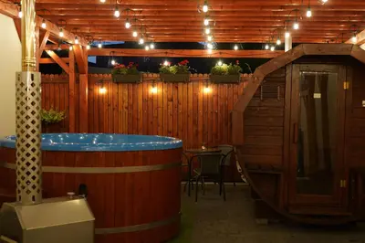 a hot tub in a room with a table and lights at Apartments ALKANTARA in Chrzanów