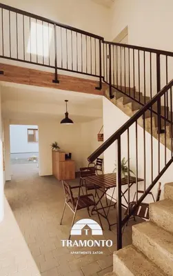 a staircase in a house with a table and chairs at Tramonto Apartments Zator Przeciszów in Zator