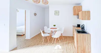 a kitchen with a table and chairs in a room at Tramonto Apartments Zator Przeciszów in Zator