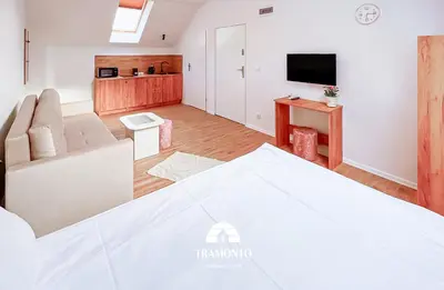 a bedroom with a bed and a living room at Tramonto Apartments Zator Przeciszów in Zator