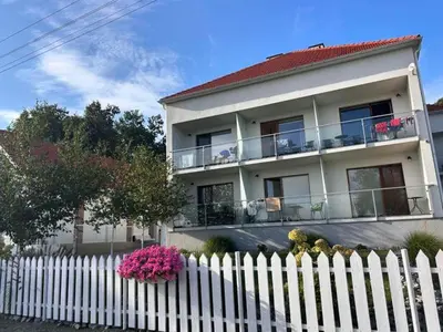 a white fence in front of a white house at Tramonto Apartments Zator Przeciszów in Zator