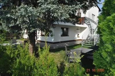 a white house with a table and chairs in a yard at Noclegi u Tadka in Zator