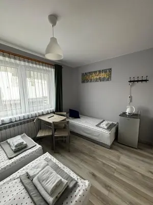 a living room with two beds and a table at Noclegi u Tadka in Zator