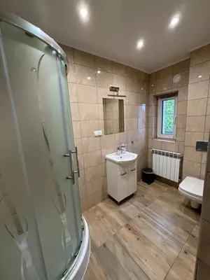 a bathroom with a shower and a sink and a toilet at Noclegi u Tadka in Zator