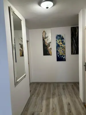 a room with three paintings on the wall and a mirror at Noclegi u Tadka in Zator