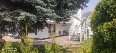 a white house with a staircase in a yard at Noclegi u Tadka in Zator
