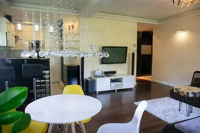 a living room with a chandelier and a table and chairs at Apartament 6 piętro in Kraków
