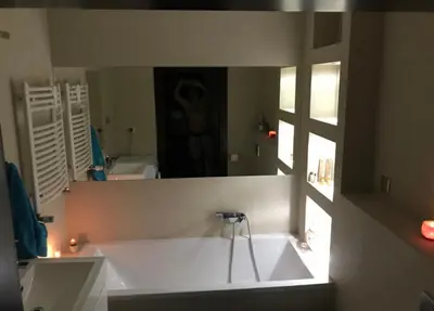 a bathroom with a tub and a person in a mirror at Apartament 6 piętro in Kraków