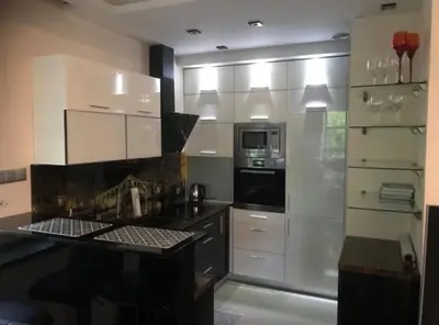 a kitchen with white cabinets and a black counter top at Apartament 6 piętro in Kraków