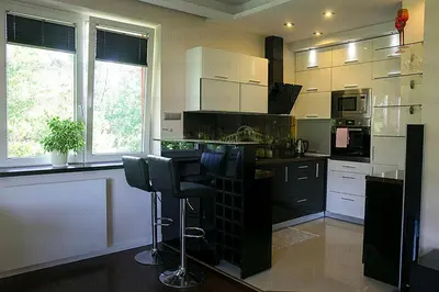 a kitchen with white cabinets and black counter tops at Apartament 6 piętro in Kraków