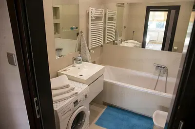 a bathroom with a sink and a washing machine at Apartament 6 piętro in Kraków