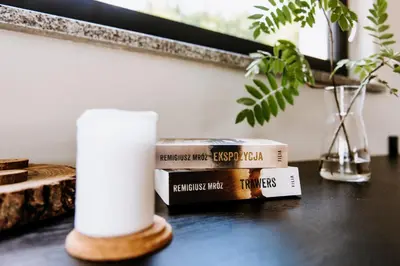 a stack of books on a table with a candle at Gorczańskie Zacisze in Lubomierz