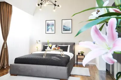 a bedroom with a bed and a pink flower at Szpitalna 9 Residence in Kraków