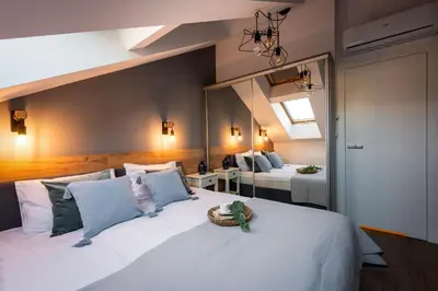 a bedroom with a large white bed with a mirror at Szpitalna 9 Residence in Kraków