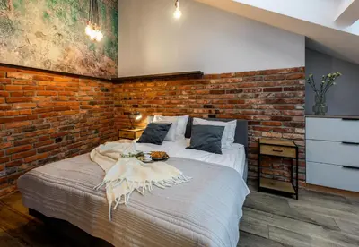 a bedroom with a brick wall and a bed at Szpitalna 9 Residence in Kraków
