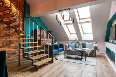 a living room with a staircase and a blue couch at Szpitalna 9 Residence in Kraków
