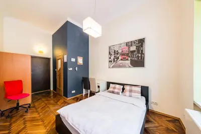 a bedroom with a bed and a red chair at Lilia in Kraków
