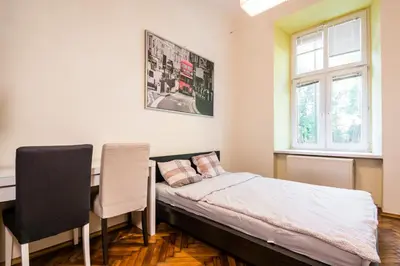 a bedroom with a bed and a desk and a window at Lilia in Kraków