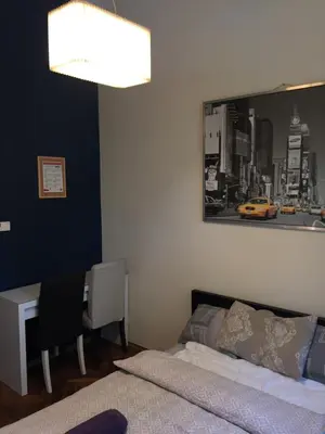 a bedroom with a bed and a desk and a picture at Lilia in Kraków