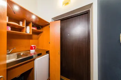 a kitchen with a wooden door and a sink at Lilia in Kraków