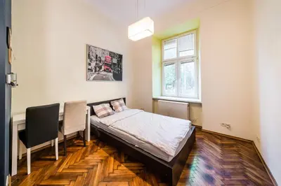 a room with a bed and a desk and a window at Lilia in Kraków
