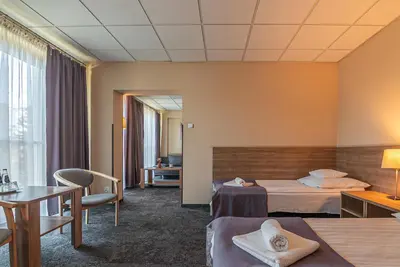 a hotel room with two beds and a table at Hotel Olimpijski in Oświęcim