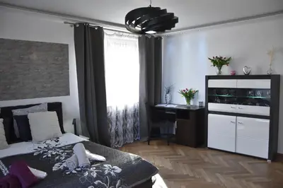 a bedroom with a bed and a desk and a window at Apartament Night Premium Krakow in Kraków