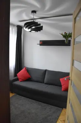 a couch in a living room with red pillows at Apartament Night Premium Krakow in Kraków