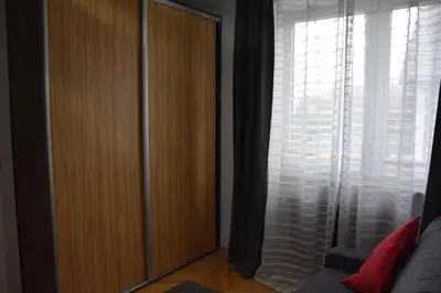 a large wooden cabinet in a room with a window at Apartament Night Premium Krakow in Kraków